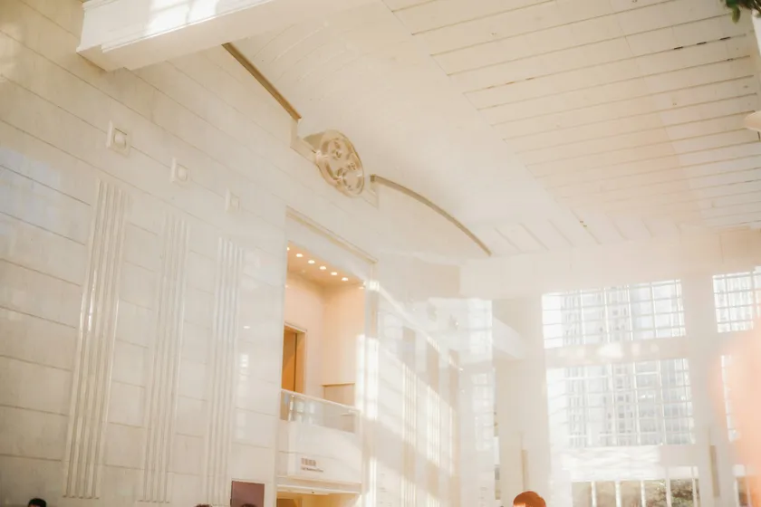 Sunlit hotel lobby with tall windows and a high white ceiling