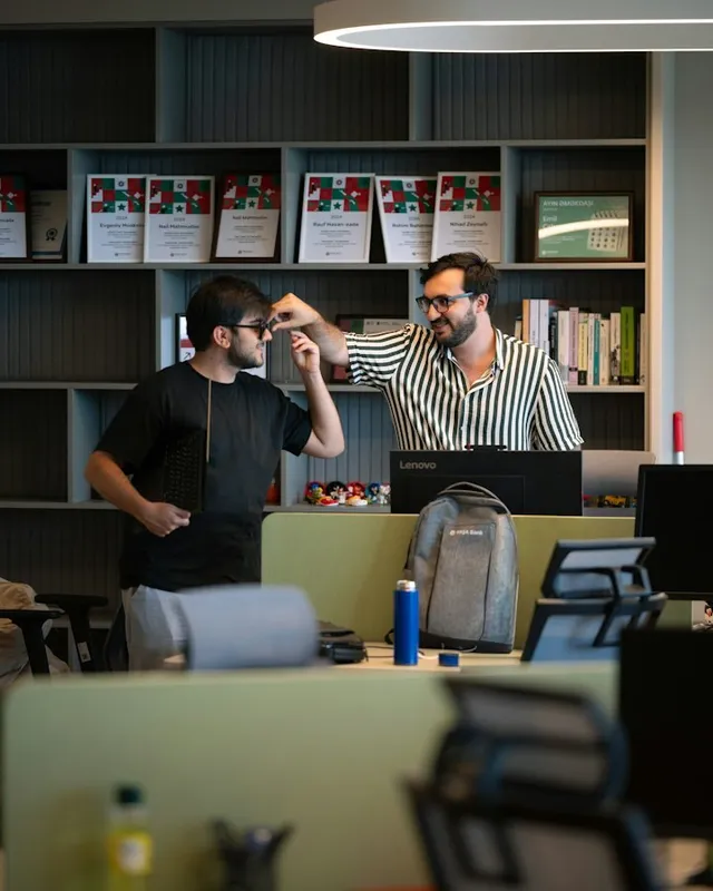 Two colleagues looking at a screen together in an office